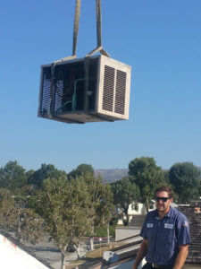 Comfort Time lifting an Air Conditioning unit onto the roof of a customer