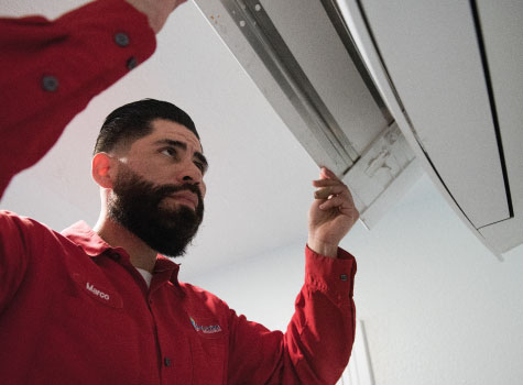 Man tunes up an AC unit